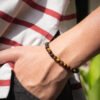Bracelet Œil de Tigre 6mm porté au poignet — pierre courage confiance